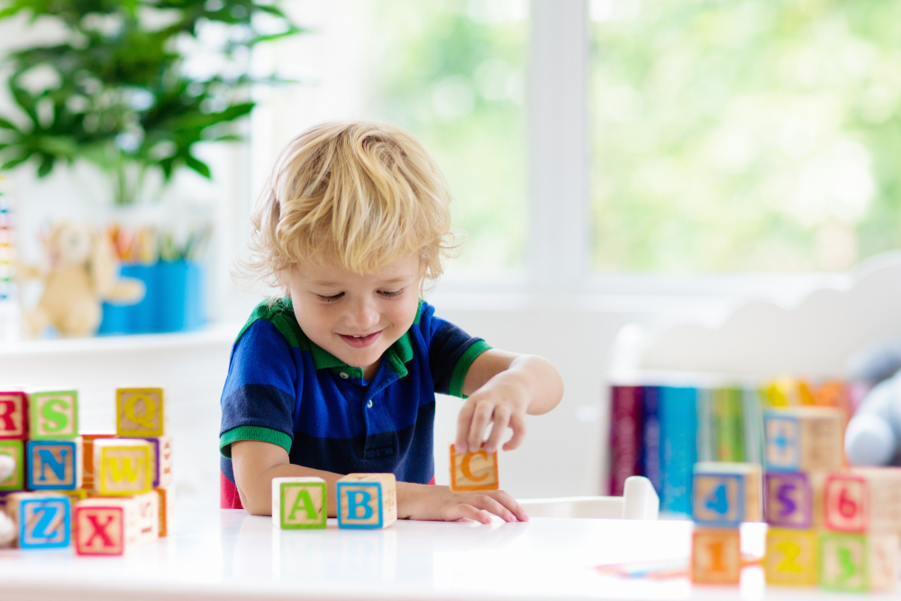 un enfant s’amuse avec des cubes en bois apprentissage de l’anglais