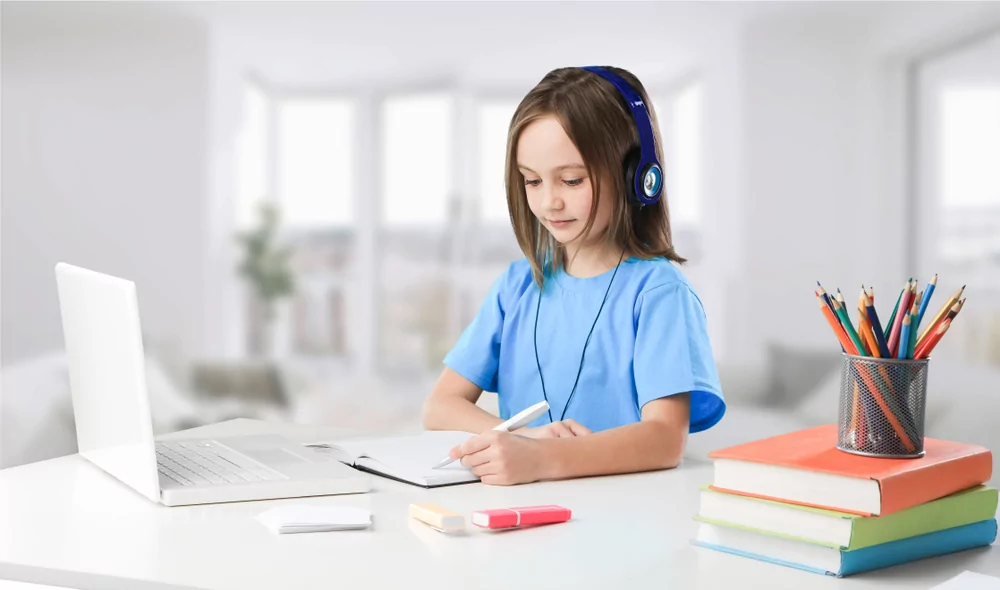 petite fille étudie en ligne avec son ordinateur et ses livres