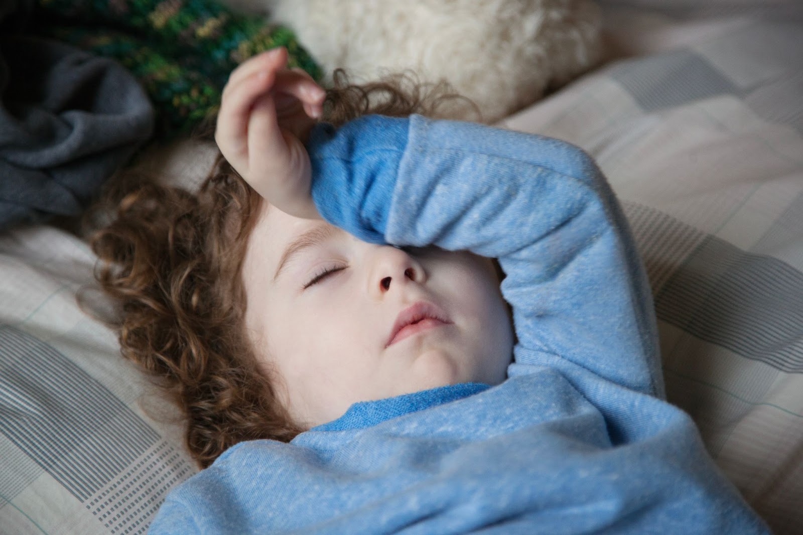 enfant fatigué endormi allongé dans un lit manque de sommeil