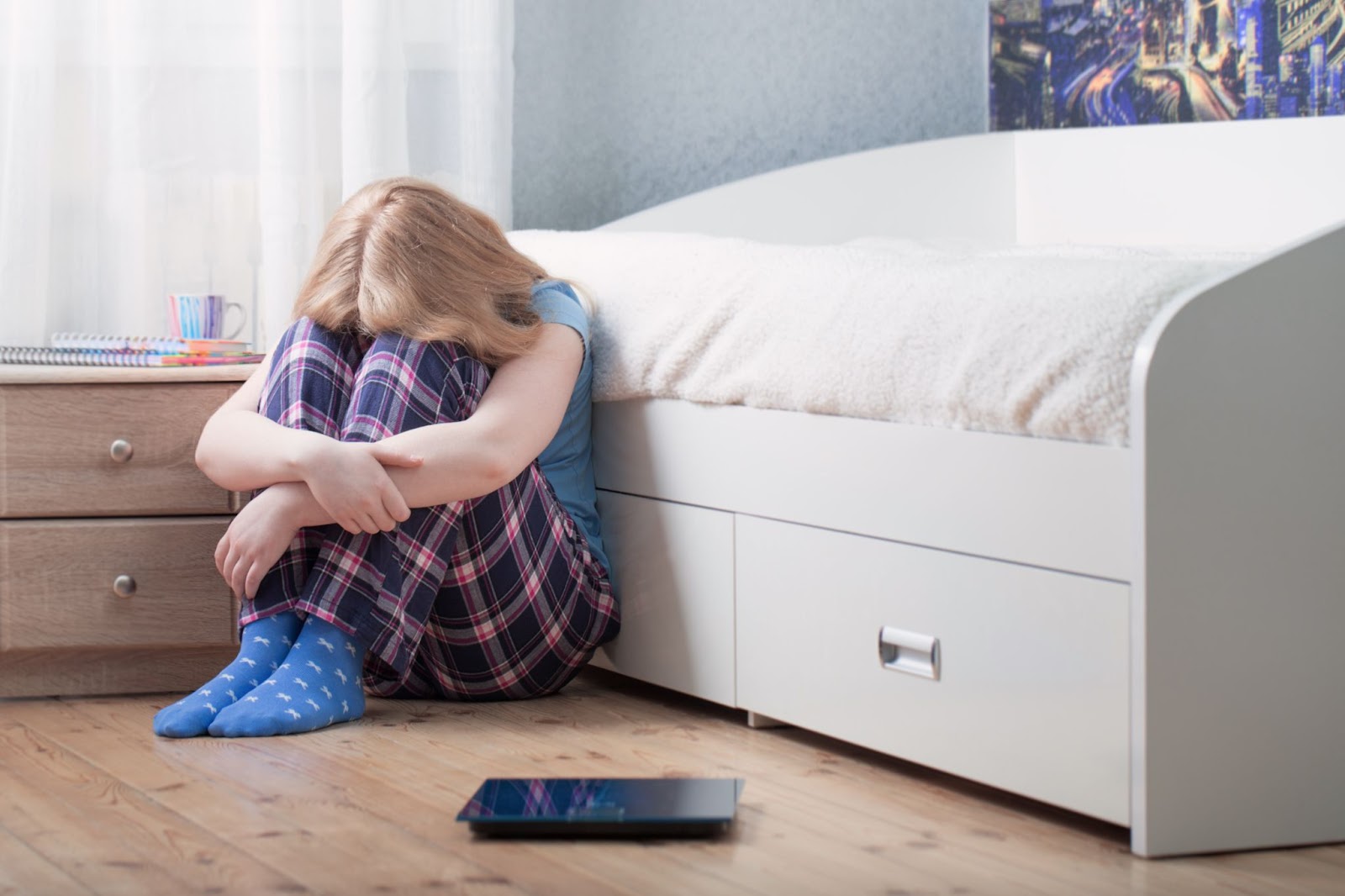 adolescente triste devant sa balance alimentation