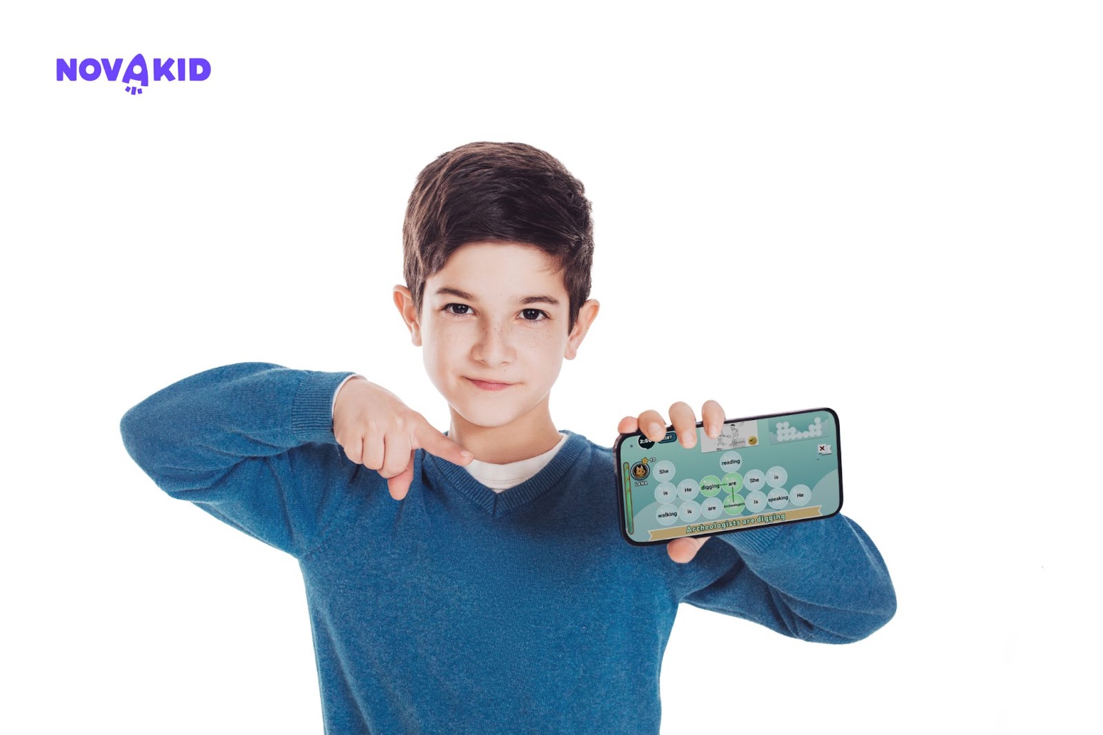 Un ragazzo ha in mano uno smartphone e sta giocando sulla piattaforma Novakid per l'apprendimento dell'inglese.